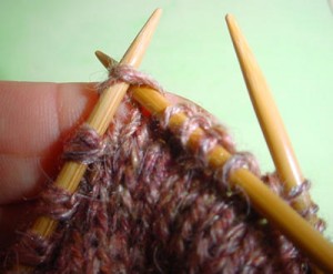 Tricoter ensuite deux rangs sur toutes les mailles (soit les 4 aiguilles), en tricotant les deux brins de chaque maille double ensembles.